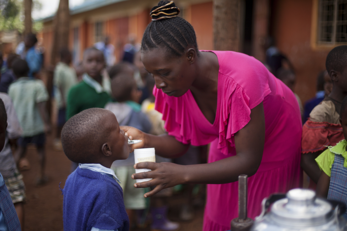 Child receiving deworming pill in Kenya