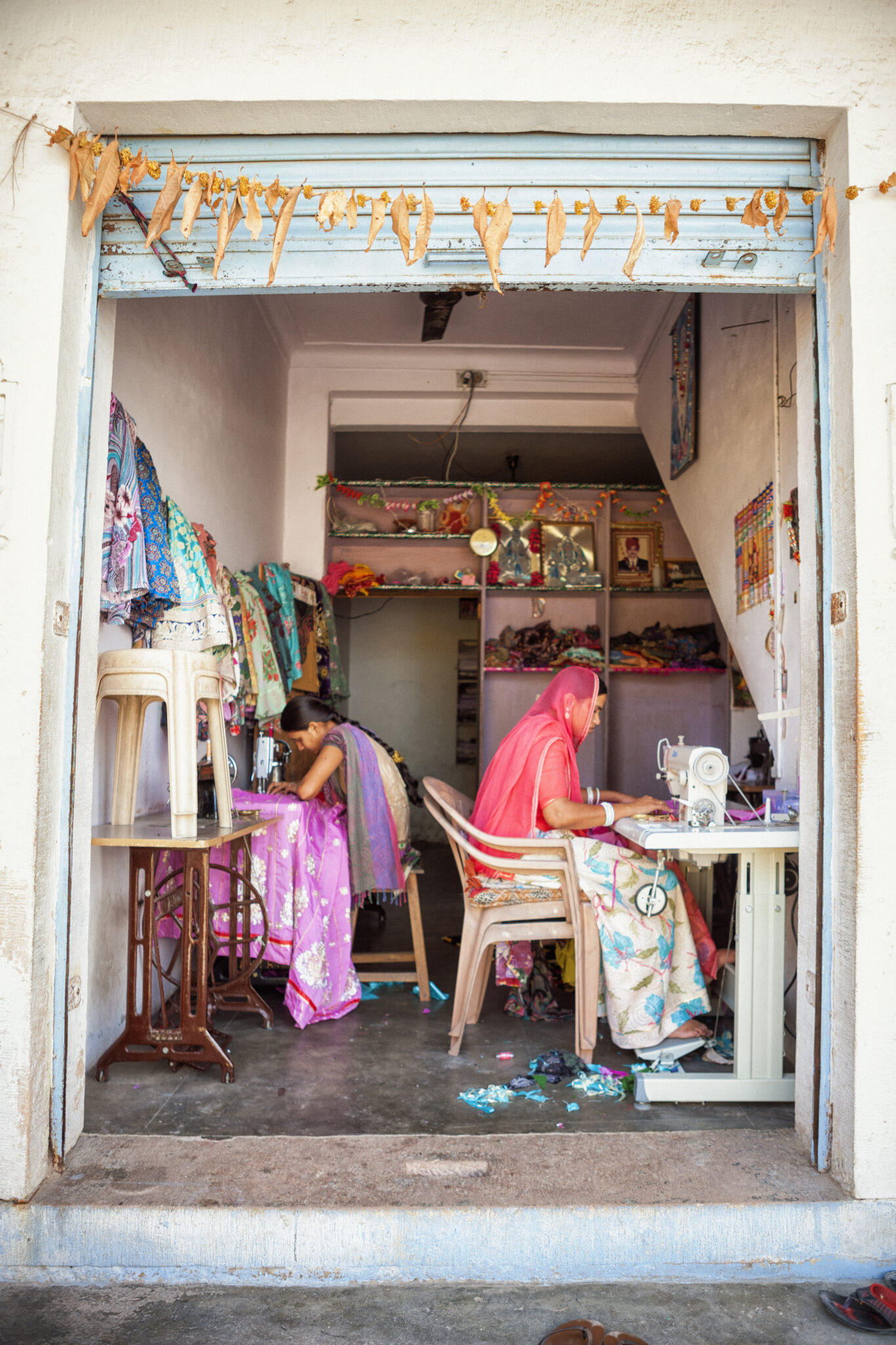Two women sewing in a small shop on the street of Nimaj, India